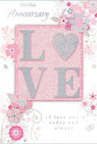 This romantic anniversary card appears as if it has been laid carefully beside a bouquet on a Bickley kitchen table, its design evoking the charm of a hand-drawn floral arrangement. In the centre, the word LOVE is featured in raised, glitter-edged letters, the texture calling to mind the delightful feel of embossed petals beneath your fingers. The letters are bathed in soft blush and pearlescent white tones, standing out against a gently glowing pink background that suggests warmth and affection rather than bold drama. Clustered around the central word, delicate blossoms in shades of blush, mauve, and ivory seem to unfurl across the card. Each flower is illustrated in fine detail with slender outlines and subtle shading in silvery grey, giving an impression of movement and lightness, as though a breeze were drifting through them. Curving vines and leaves weave between the blooms, adding rhythm and flow, while tiny swirls and almost-hidden butterflies introduce a playful, whimsical note to the composition. The phrases On Our Anniversary and I love you today and always are written in a graceful script, their smooth curves echoing the gentle arcs of the flowers and foliage. The layout feels spacious and thoughtfully arranged, similar to how a florist spaces stems so each bloom has room to shine. The overall mood is of tender celebration and enduring closeness, like an evening spent reminiscing in Bickley after a quiet walk beneath the trees, marking another year of shared moments with something beautiful, gentle, and sincerely meant.